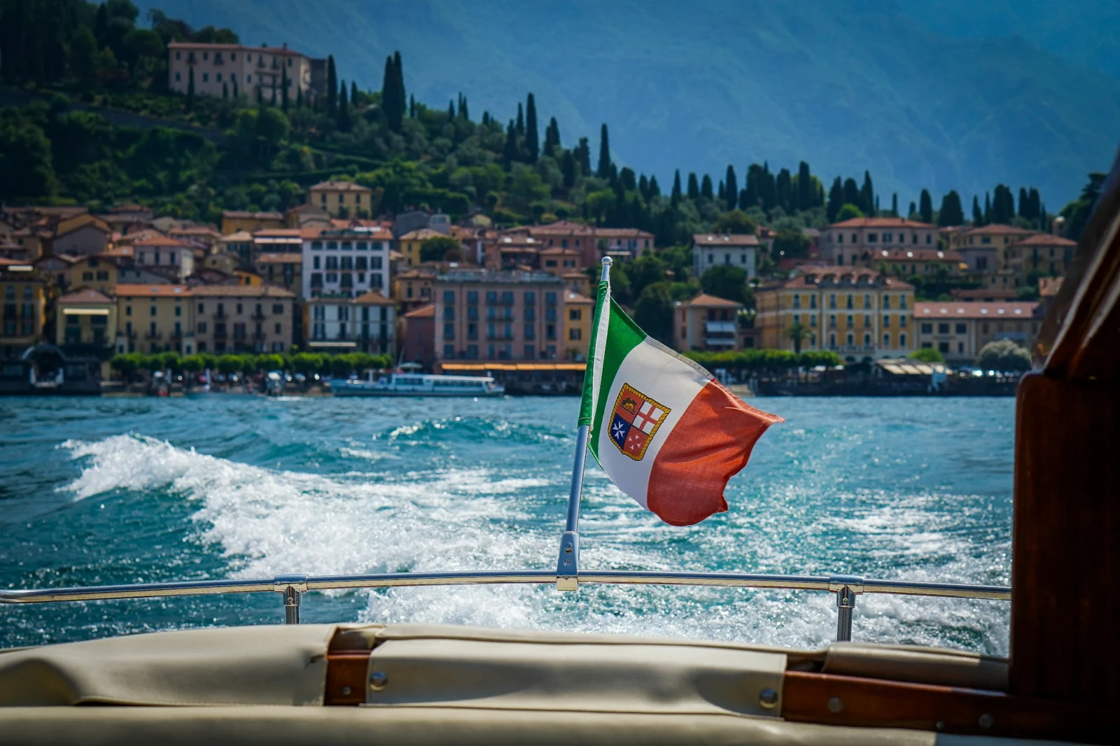 Wooden boat with the Italian flag cruising on Lake Como